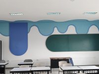 Interior sekolah dasar IPEKA dengan papan tulis, papan mading, dan mural dinding edukatif